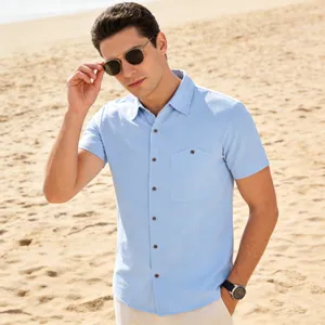 Beach scene detail of men's light blue short sleeve casual linen shirt with chest pocket.