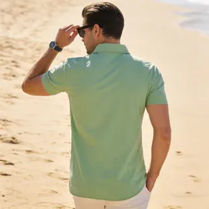 Detail of mens light green short sleeve linen shirt worn on sunny beach background.
