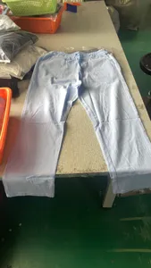Detailed view of men's casual light blue linen trousers, featuring elastic drawstring waist.