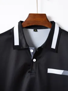 Black polo shirt detail view, featuring contrast white lapel collar and button placket.