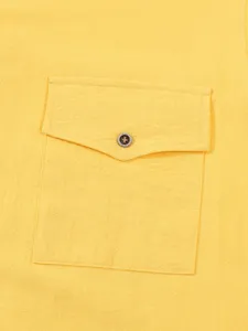 Primer plano del detalle del bolsillo en el pecho de camisa de lino amarillo con botón.