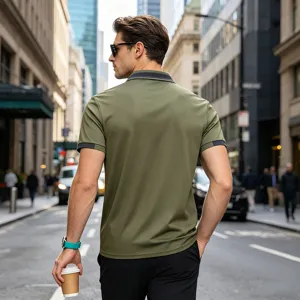 Close-up detail of olive green polo shirt collar and sleeve design in urban street setting.