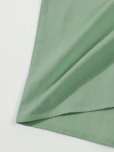 Light green men's casual linen short sleeve shirt fabric and bottom hem detail.