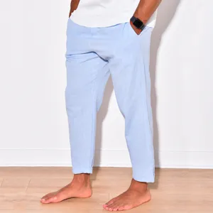 Detail shot of men light blue casual linen trousers, summer beach streetwear style pants.