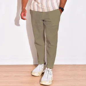 Close-up view of men's casual linen trousers in olive green, showing fabric texture and fit.