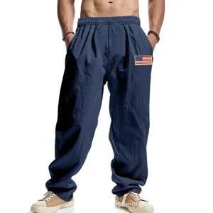 Close-up detail of men's blue casual linen trousers featuring comfortable drawstring waist and flag patch.