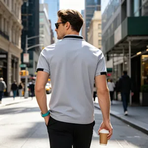 Casual grey men's short sleeve polo shirt with black contrast collar and cuffs in street view.