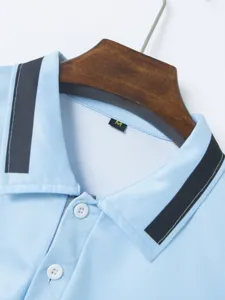 Close-up view of the light blue men's polo shirt collar, stylish buttons and fabric texture.