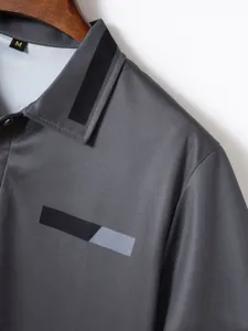 Close-up detail of men's casual polo shirt collar, gray mesh fabric with striped design.