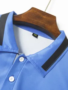 Men's blue polo shirt collar detail view, showcasing contrast black lapel and white buttons.