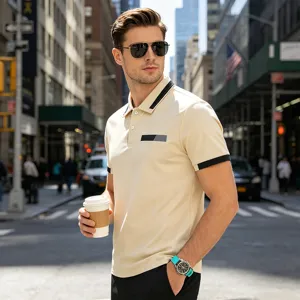 Detail view of men's short sleeve polo shirt with contrasting black collar, cuffs and chest pocket.