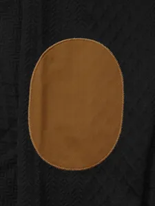 Close-up detail shot of men's sweater featuring a contrast brown oval elbow patch design.