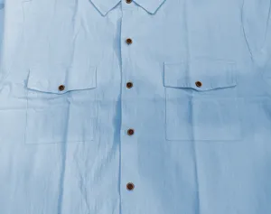 Detalle de camisa casual de hombre en lino de manga corta con dos bolsillos y botones retro.