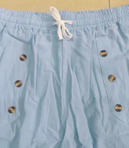 Close-up detail of light blue casual cargo pants waist with white drawstring and buttons.