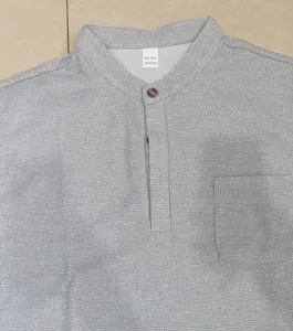 Grey waffle fabric men's short sleeve shirt detail with button placket and chest pocket.