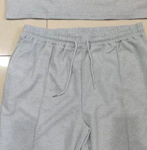 Close-up detail of gray waffle knit casual pants texture and drawstring waistband.