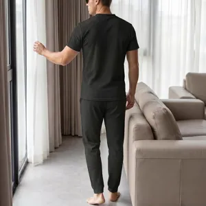 Detail view of men's waffle knit short sleeve top and trousers set in dark green.