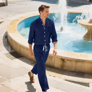 Detailed view of a men's dark blue linen long-sleeve shirt and trousers set worn outdoors.