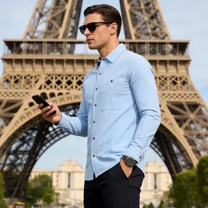 Detailed shot of a stylish men's light blue long-sleeve linen shirt worn outdoors.