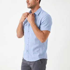 Detailed shot of a light blue short sleeve mens linen shirt with chest pockets and buttons.