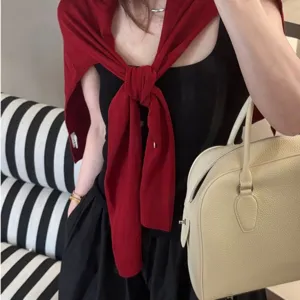 Vue détaillée d'un élégant châle en tricot rouge sur les épaules, idéal pour un style chic quotidien.