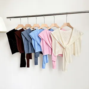Detailed view of hollow knit shawl color variants hanging on rack for women spring summer style.