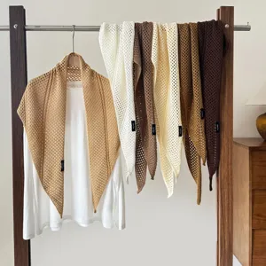 Detailed view of the hollow knit triangular shawl, wool blend, elegant scarf and outerwear.