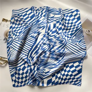 Detalle de pañuelo de seda con patrón geométrico azul y blanco, diseño de estampado abstracto.