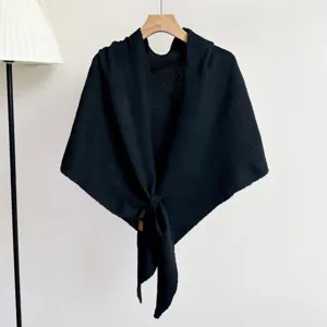 Gedetailleerde close-up van een comfortabele zwarte gebreide driehoekige sjaal op hanger.