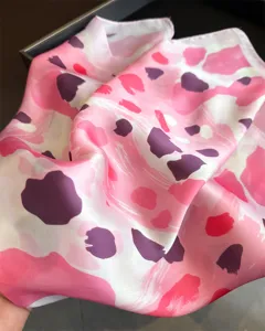 Close-up detail of a pink and purple abstract leopard print silk scarf, elegant fabric texture.