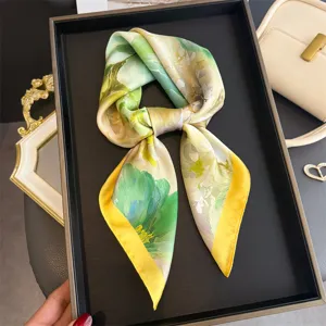 Foulard en soie imprimé en détail avec motif floral vert et jaune et tissu doux.
