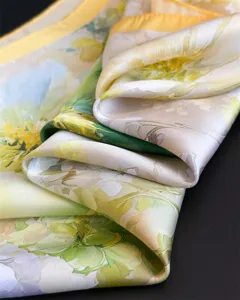 Vue détaillée d'un foulard en soie pour femmes à imprimé floral et bordure jaune.
