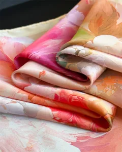 Gros plan detaille du foulard en imitation soie imprimee florale montrant texture et eclat.