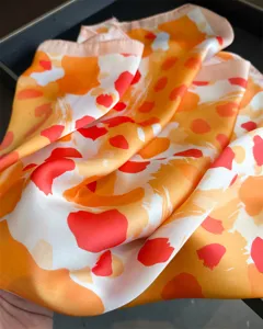 Exquisite leopard print silk scarf detail, vibrant orange design, elegant neckerchief.