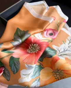 Elegant orange silk square scarf with vibrant floral print, premium fashion accessory for women.