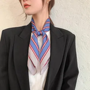 Detailed view of a chic blue and red striped scarf worn elegantly with a black blazer.