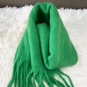 Green mohair scarf detail, fluffy winter neck warmer, soft tassel cozy knitwear close up.