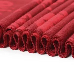 Close-up detail shot of red winter scarf edge texture and fine hemming craftsmanship.