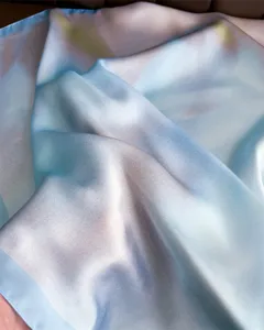 Close-up view of the smooth gradient silk square scarf, highlighting soft texture and glossy sheen.
