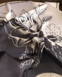 Close-up view of a stylish black and white floral print silk scarf detail and texture.