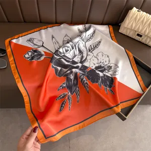 Silk square scarf with orange white color block and black rose floral print detail.