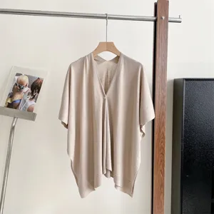 Detailed view of women's summer beige knit sun protection shawl cape with single front button.