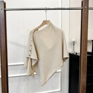Knitted poncho detail view, beige woolen shawl texture and metal button decoration showcase.
