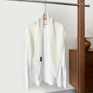 Detailed close-up view of white knitted hollow triangle shawl scarf outer wear, premium knit.