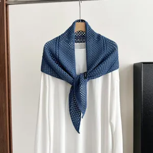 Blue hollow knit triangular shawl scarf paired with white top, elegant wool blend outerwear piece.