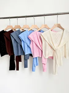 Detailed view of hollow knit shawl in multiple colors, featuring delicate floral pattern design.
