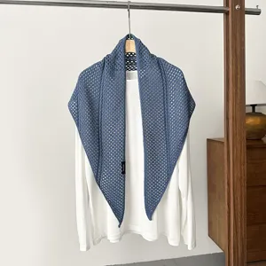 Blue hollow crochet knitted triangle shawl paired with white long sleeve shirt outer wear.