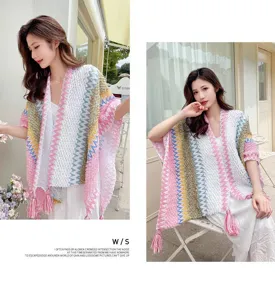Ethnic style knitted tassel cape detail view, colorful pattern and cozy wool fabric.