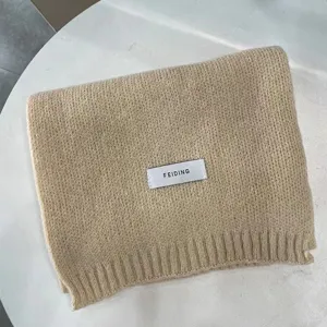 Knitted scarf detail showing soft winter neck warmer texture and beige solid design.