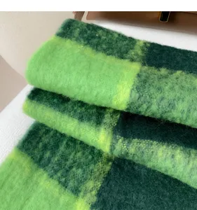 Detailed shot of a cozy green plaid fuzzy winter scarf, soft mohair texture, warm and stylish.